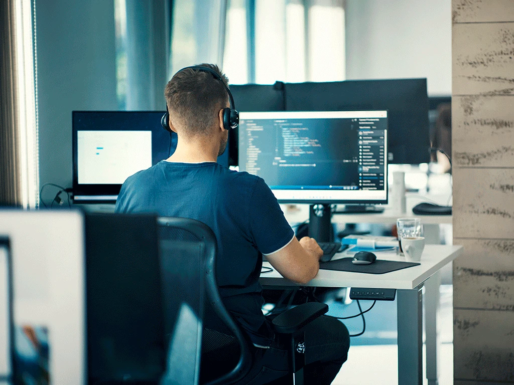 Ingeniero de sistemas programando en una pantalla grande - Utadeo