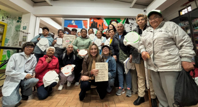 Estudiantes de Utadeo junto a las mujeres de la tercera edad a quienes les dan el taller de tejido Estudiantes de Utadeo posan junto a un grupo de adultas mayores con quienes comparten en un taller de tejido