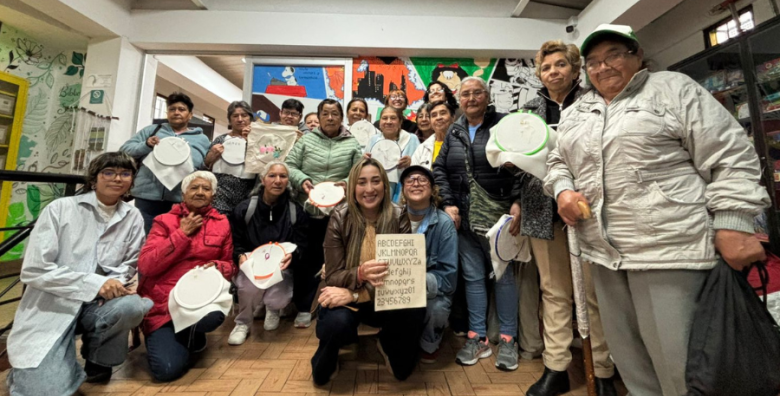 Estudiantes de Utadeo posan junto a un grupo de adultas mayores con quienes comparten en un taller de tejido