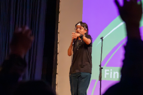 Estudiante tadeísta cantando en el Aula Máxima